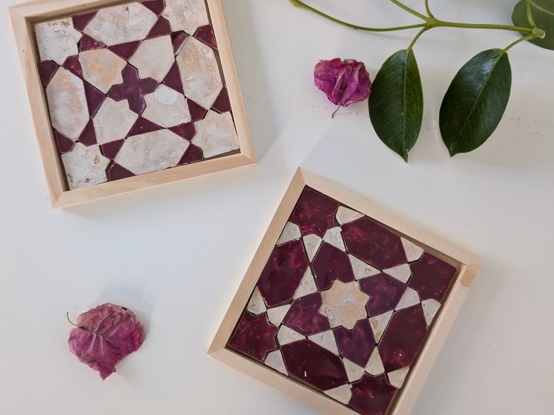 Two burgundy and cream coasters with leaves and petals